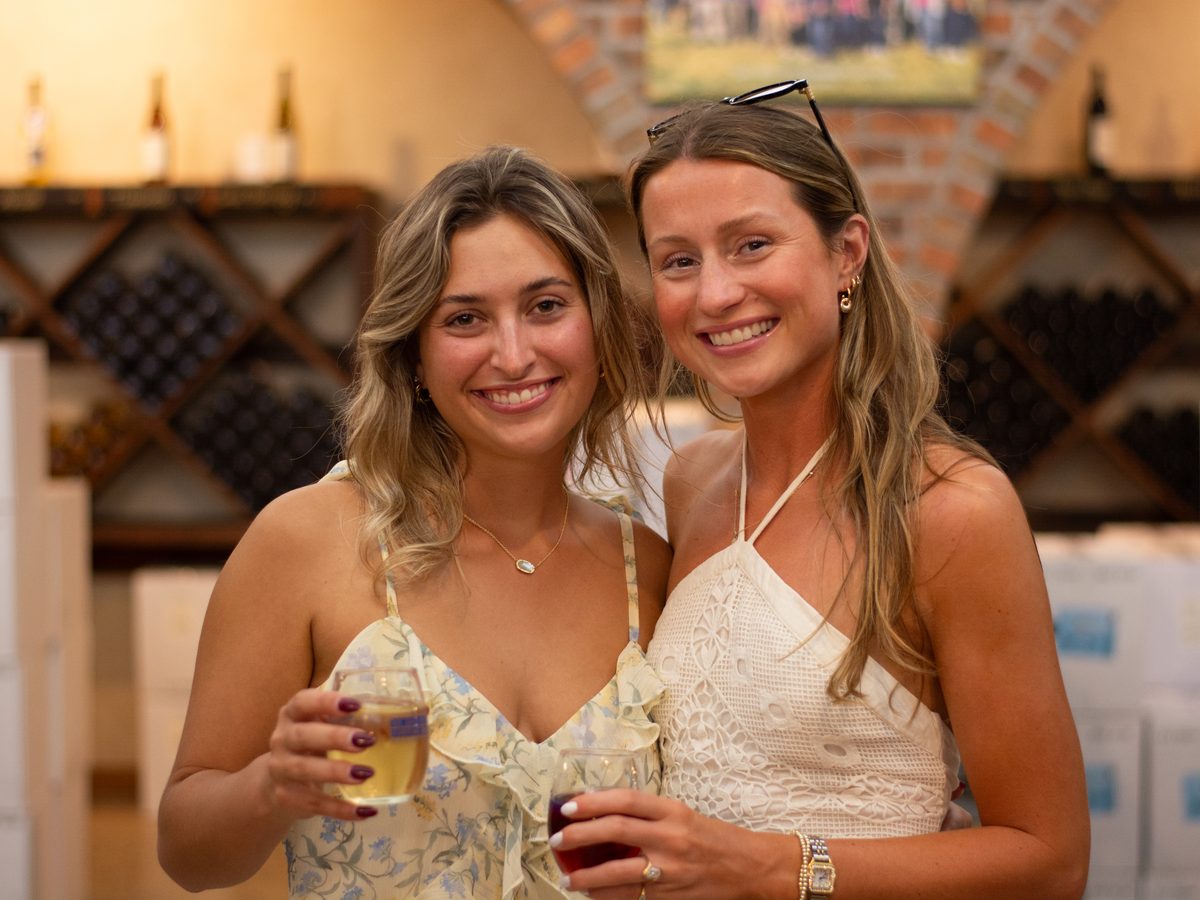 Two guests with glasses of Fenn Valley wine among the cellar racks.